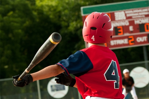 young child playing baseball outdoors