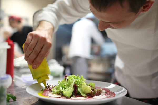 Chef placing garnish on dish