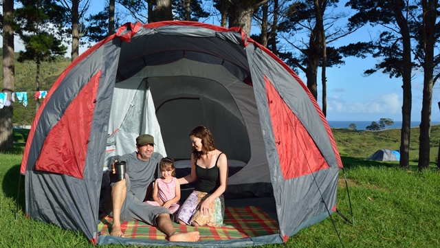 Family sitting inside of a tent during Summer